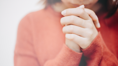 close up of a woman's hands folded in prayer