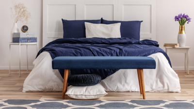 a cosy bedroom with blue linens and rug