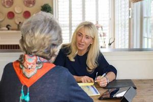 Lucy, seated at her desk, speaking with a client